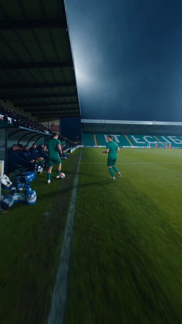 Two footballers training alongside the team bench
